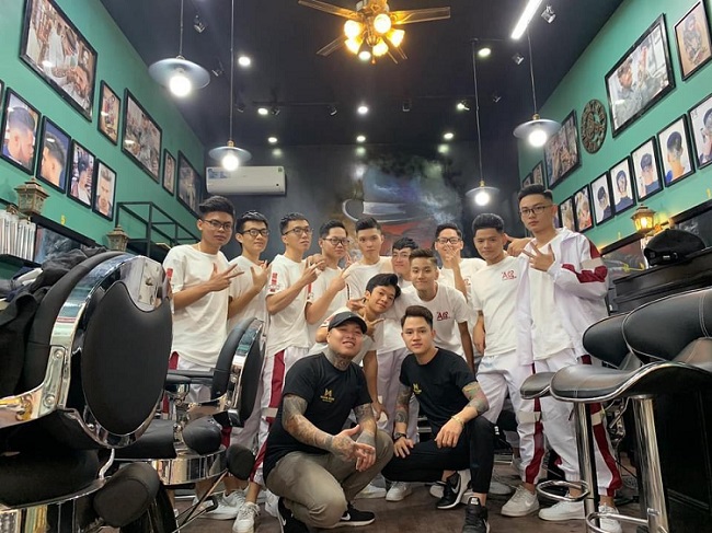 Đội ngũ thợ đang chụp hình cùng khách hàng tại Minh Hiếu Barbershop